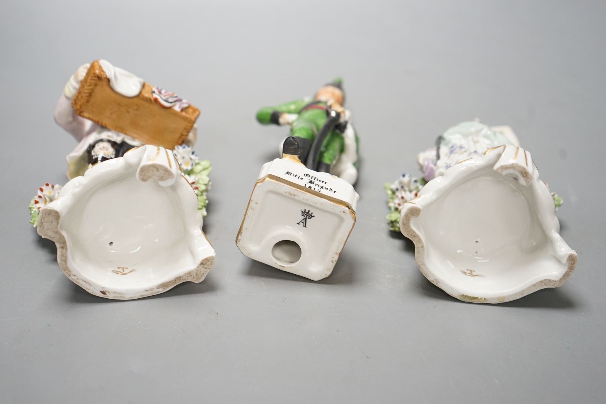 A pair of Dresden porcelain figures of a street-trader and companion and a continental porcelain figure of a Rifle Brigade officer (3) 19.5cm
